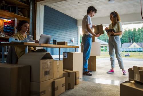 Male Caucasian Manager Using Laptop To Fill Online Orders, Hispanic Female Co-Founder